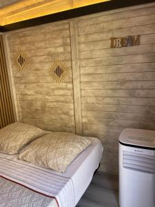 a bed in a room with a wooden wall at Cabane insolite avec jacuzzi in Menton