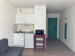 a small kitchen with a table and a microwave at Studio à Bussy St Georges in Bussy-Saint-Georges