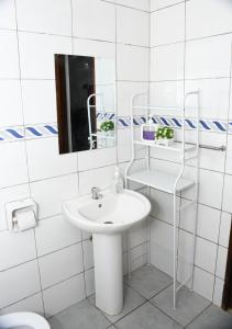 a white bathroom with a sink and a mirror at Caramel Home in Mombasa