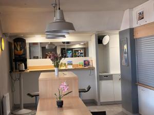 a kitchen with a table with flowers on it at Unisotel GAP -" Ex HôtelF1" in Gap