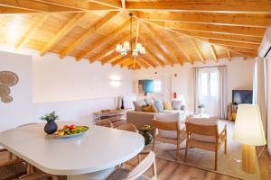 a kitchen and living room with a white table and chairs at Casa Amarela do Redondo in Seixal