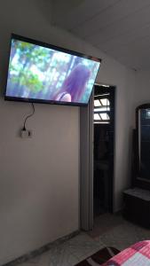 a flat screen tv hanging on a wall at Chalé da Elba 01 Ilhabela in Ilhabela