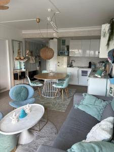 a living room with a couch and a table at Ma Mère Beach Condo Oostende in Ostend