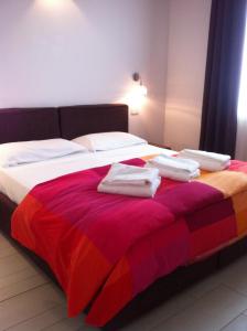a bedroom with a bed with towels on it at La Fattoria Apartments in Lazise