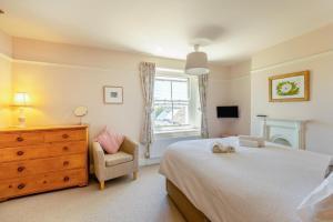 a bedroom with a bed and a chair and a dresser at 3 Bed in Bridport oc-dc160 in Bridport