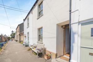 a white building with benches on a street at 3 Bed in Bridport oc-dc160 in Bridport