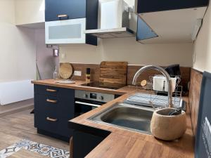 a kitchen with blue cabinets and a sink at Au Souffle Marin Maison 2 chambres in Berck-sur-Mer