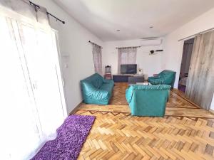 a living room with two blue chairs and a television at Moradia Aura Santi in Esposende