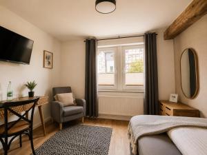 a bedroom with a bed and a chair and a window at Boutique Hotel Marielle in Bad Münstereifel