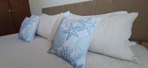 a bed with blue and white pillows on it at Condo Sunset in Cabo San Lucas +20 photos
