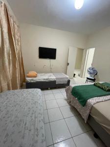 a room with two beds and a flat screen tv at Apartamento em Seabra in Seabra