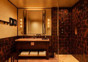 a bathroom with a sink and a shower with a mirror at Bourbon Hôtel in Courchevel