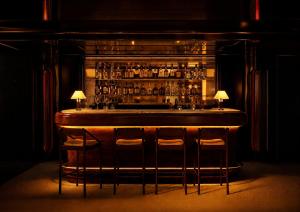 a bar with stools in a room with a bar at Bourbon Hôtel in Courchevel