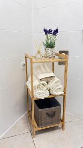 a bamboo shelf with towels and a basket in a bathroom at Apartment Niki in Siegendorf im Burgenland +5 photos
