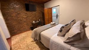 a bedroom with a bed and a brick wall at The Willows in Polokwane