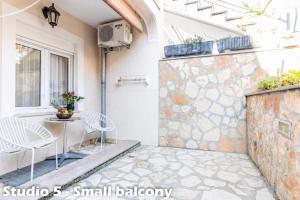 a patio with a small balcony with a table and chairs at Apartments Jurić in Vrsar