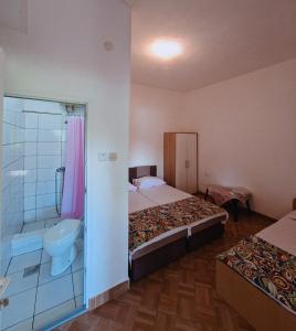 a bedroom with two beds and a bathroom with a shower at Camping 999 Jablaničko jezero in Železnička Stanica Ostrožac