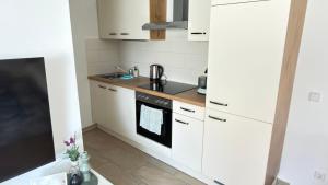 a kitchen with white cabinets and a stove top oven at Apartment Niki in Siegendorf im Burgenland