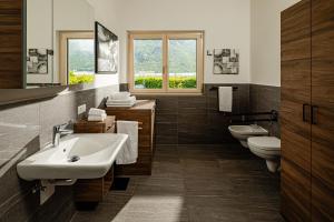 a bathroom with two sinks and two toilets at Rauchhof Apartments in Auer