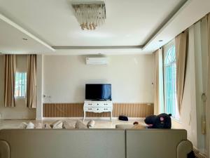 a living room with a couch and a tv at Paiyawadee House khaoyai in Ban Hua Phrong