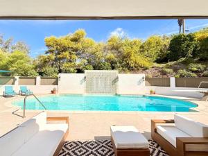 a swimming pool with white furniture in a yard at Lavender House and Guest House in Ojai