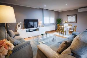 a living room with two couches and a tv at Casa dos olivos in Ourense