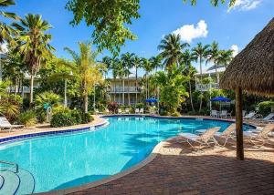 a large swimming pool with chairs and a resort at Coral Hammock Poolside Home in Key West