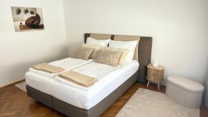 a bed with white sheets and pillows in a room at Apartment Niki in Siegendorf im Burgenland