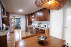 a kitchen with wooden cabinets and a wooden table at Casa dos olivos in Ourense
