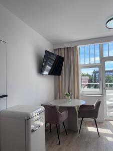 eine kleine Küche mit einem Tisch und einem Fenster in der Unterkunft Villa Amadea in Misdroy