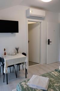 a white room with a table and a tv on the wall at The View in Satu Nou de Sus