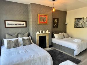 two beds in a room with a fireplace at The Cloud in Alderley Edge +11 photos