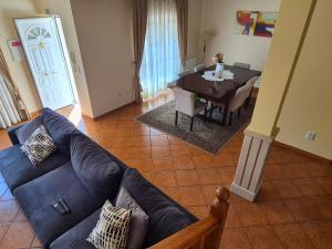 a living room with a blue couch and a table at Toca dos Coelhos in Silveira