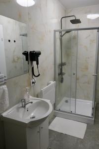 a bathroom with a sink and a glass shower at The View in Satu Nou de Sus