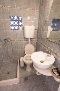 a bathroom with a toilet and a sink at Mania Rooms and Studios in Poros +36 photos