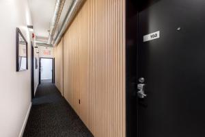 a hallway with a black door with a sign on it at Lofts Le Plateau in Montreal