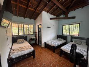 a room with two beds in a room with windows at Hotel para descanso con piscina in San Gil
