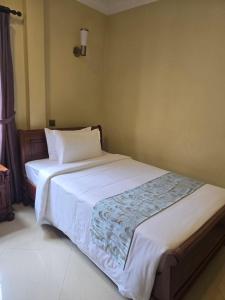 a bedroom with a large white bed in a room at LT Home Stay in Siem Reap