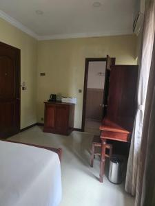 a bedroom with a bed and a chair and a piano at LT Home Stay in Siem Reap