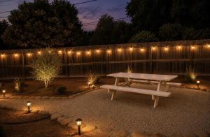 a picnic table in a backyard with lights on a fence at Ojai Pixie House in Ojai +2 photos
