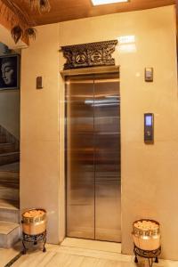 a stainless steel elevator in a building with two barrels at Hotel Swastik in Kathmandu