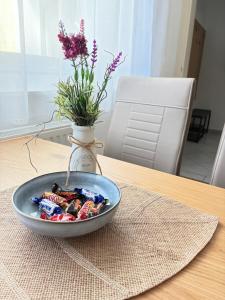 a bowl of candy on a table with a vase at Apartment Niki in Siegendorf im Burgenland