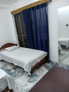 a bedroom with a bed and a window with a mirror at Shahi House in Bodh Gaya