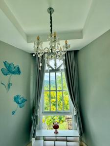 a chandelier in a room with a large window at Paiyawadee House khaoyai in Ban Hua Phrong +38 photos