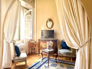 a living room with a tv and a table and chairs at Chateau de Murviel in Murviel