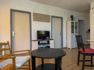 a living room with a table and chairs and a television at Res Roncaccio, Cancro by HolAp SA in Vairano
