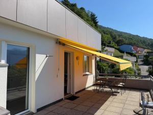 a balcony of a house with a table and chairs at Res Roncaccio, Cancro by HolAp SA in Vairano