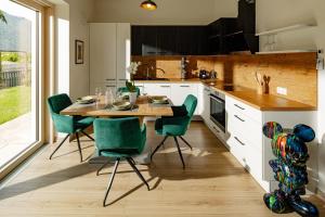 a kitchen with a wooden table and green chairs at Rauchhof Apartments in Auer +7 photos