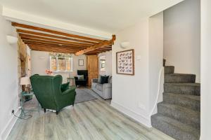 a living room with stairs and a green chair at Malvern House in Banbury
