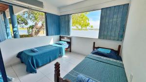 two beds in a room with a view of the water at Xodó da Lagoa in Beberibe +103 photos